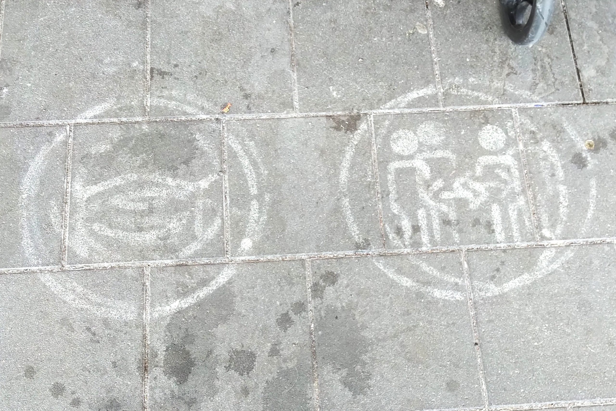 Weiße Symbole auf dem Boden weisen auf das Tragen von Masken hin.