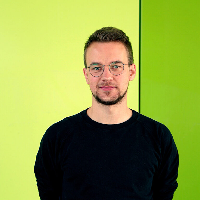 Michael Papendick steht vor einer hellgrünen Wand.